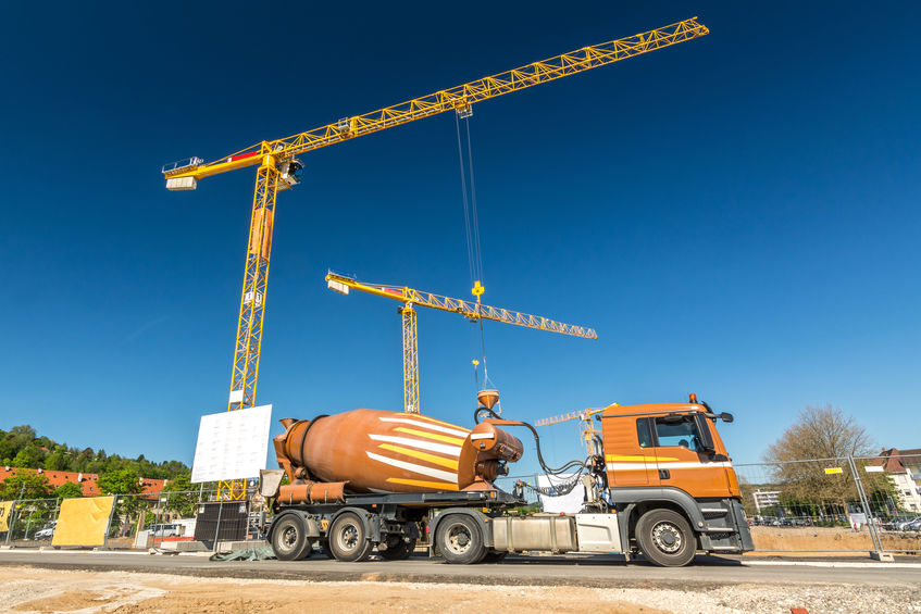Construction site with concrete mixer truck and cranes