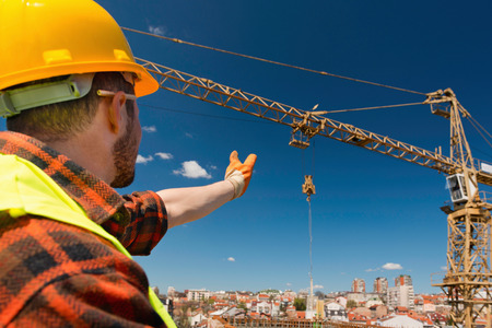 Construction Worker Directing a Crane