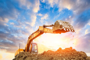 heavy equipment machine digging at construction site at sunrise