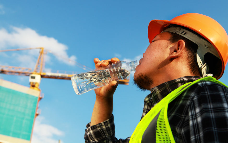 Construction worker drinking water on a location site