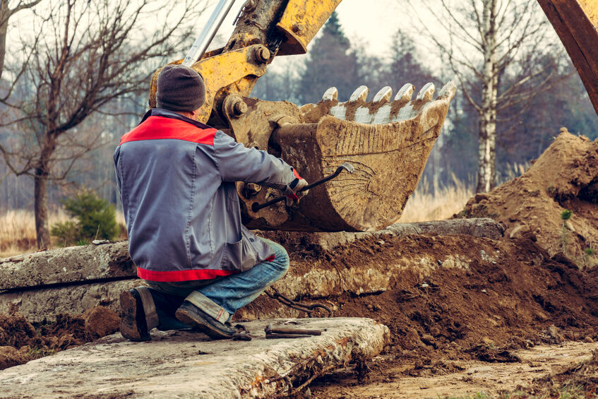 Construction worker outside in autumn dealing with damp, muddy conditions